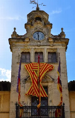 Town hall with clock and Catalan flag in Alcúdia.