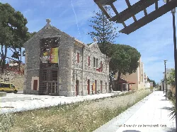Bahnhof von Artà mit Steinfassade und Ziegeldach, umgeben von Bäumen.