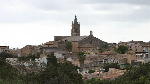 Stadtansicht von Llubí mit Kirche und Häusern.