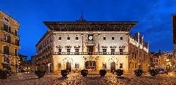 Ayuntamiento de Palma de noche, fachada iluminada, cielo despejado.