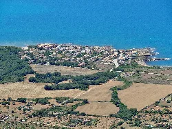 Luftaufnahme von S’Estanyol mit Blick auf das Meer und die umliegenden Felder.