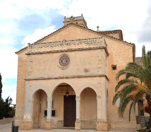 Fassade der Kirche Nuestra Señora de Atocha mit Palmengarten in Ariany.