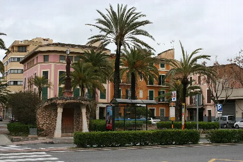 Palmen und Gebäude an der Plaza de sa Mora in Manacor.